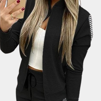 
Women's rose gold velvet tracksuit with sequin detail, featuring long sleeves, a high neck, and waistband. The tracksuit is worn by a model with layered hair, shown in a black and XL variant, capturing a luxury activewear style.