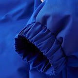 Royal blue men's insulated windproof puffer jacket displayed against a clear sky background.