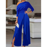 A woman wearing a royal blue one-shoulder wide-leg jumpsuit in size 3XL, suitable for formal cocktail attire.