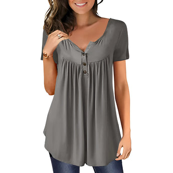 A woman standing and smiling, wearing a royal blue pleated scoop neck blouse with short sleeves.
