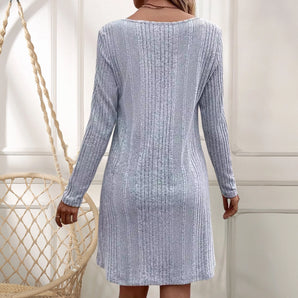 Women's silver ribbed long sleeve knit sweater dress featuring a stylish backless design, perfect for winter fashion. The dress showcases a fitted silhouette with a subtle textured pattern across the fabric.