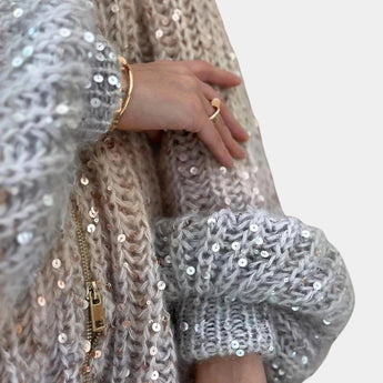 Silver sequin bridal shawl draped elegantly over a woman's shoulders, showcasing intricate embellishments and sparkling design. The shawl complements an evening or bridal outfit, adding a touch of glamour and sophistication.