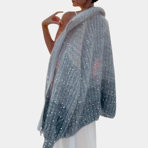 Silver sequin bridal shawl for women, elegantly draped as an evening wrap with shimmering sequins, showcasing a fashionable design over the shoulders.