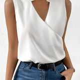 Sleeveless white wrap blouse featuring an elegant V-neck design, suitable for business attire.