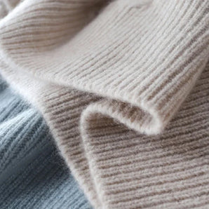 Luxurious beige lightweight cashmere crewneck winter sweater displayed on a flat surface, showcasing its soft woolen texture and exquisite woven fabric detail.