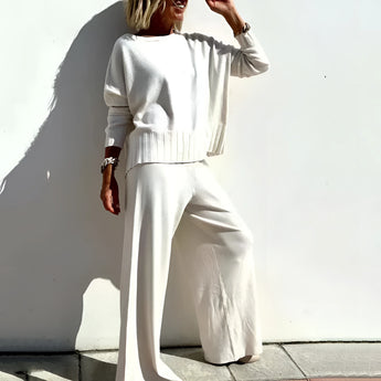 Sophisticated taupe loungewear set for mature women in white, size 3XL, featuring a relaxed fit with long sleeves and a collared neckline. The image shows a woman modeling the comfortable outfit, highlighting the waist and shoulder areas, with the addition of stylish sunglasses.