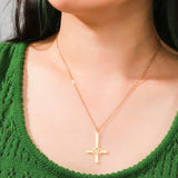 A silver gear cross pendant necklace with a steampunk design, displayed on a green background. The necklace is worn around the neck, highlighting its industrial Christian jewelry style.