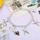 Sterling silver starfish jewelry set including necklace, bracelet, and earrings displayed against a white background.
