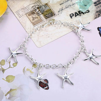 Sterling silver starfish jewelry set including necklace, bracelet, and earrings displayed against a white background.