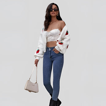 Women's trendy V-neck strawberry knit cardigan worn with denim jeans, highlighting the garment's waist and sleeve details.