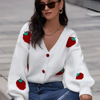 
Woman wearing a strawberry knit cardigan with a trendy V-neck design, featuring long sleeves and a waist-length fit, accessorized with stylish eyewear.