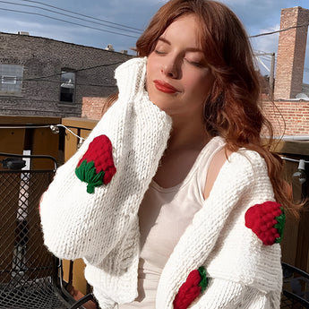 Women's trendy strawberry knit cardigan with a V-neck design, worn by a model with long hair and fashionable eyewear.