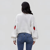 Women's trendy V-neck strawberry knit cardigan with long sleeves, modeled paired with jeans, showcasing a casual and stylish outerwear look.