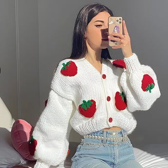 Women's trendy strawberry knit cardigan in red, featuring a V-neck design and long sleeves, worn by a model with black hair. The model is showcasing the cardigan, drawing attention to the garment's fit along the chest, waist, and arms, and emphasizing the stylish and cozy appearance of the sweater in an XL size.