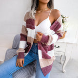A woman wearing a striped black and white long sleeve cardigan in a fall fashion knitwear style. The cardigan features a chestnut brown hue and is worn in a size large. The image captures the full upper body of the woman, highlighting the cardigan's design and fit against a neutral background.