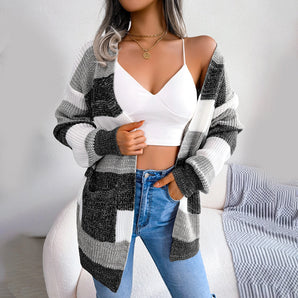 A woman wearing a striped black and white long sleeve cardigan with a relaxed fit, perfect for fall fashion. The cardigan features a stylish collar and is complemented by the woman's black hair.