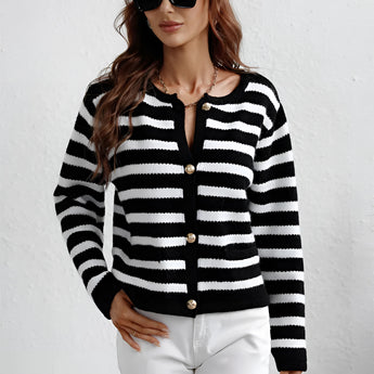 A person wearing a striped blue and white knit cardigan sweater with a button-up design, featuring a collar and sleeves.