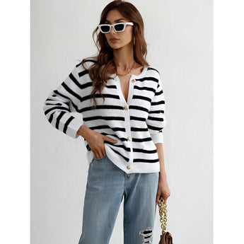 Striped blue and white knit cardigan featuring a button-up design, modeled in a casual chic style on a person wearing the sweater in size XL. The cardigan is displayed in a relaxed setting, highlighting its cozy and fashionable appearance.