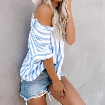 Woman wearing a striped blue and white V-neck summer blouse paired with distressed denim shorts.
