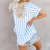 Woman wearing a striped blue and white V-neck summer blouse paired with distressed denim shorts, focusing on the clothing and textile details.