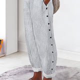 Striped button-up lounge pants in grey, styled for summer with lightweight fabric; shown on a model standing indoors on a wooden floor.