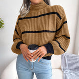 Tan and black striped chunky turtleneck sweater, featuring long sleeves and a comfortable fit, styled with jeans.
