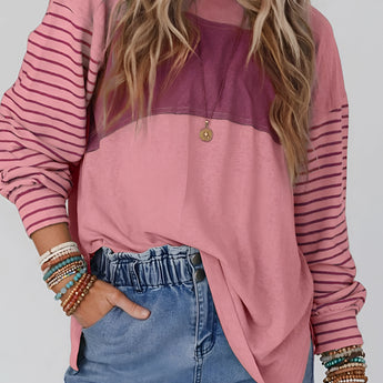 
A woman wearing a striped color block long sleeve casual pullover sweater, featuring a mix of colors and a relaxed fit. She is smiling and posing, showcasing the sweater's fashionable design and comfortable fabric.