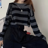 Striped oversized black and white knit sweater featuring long sleeves and a crew neck, perfect for trendy autumn fashion.