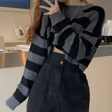 Striped oversized black and white knit sweater featuring a trendy autumn fashion design with long sleeves and a round neckline.