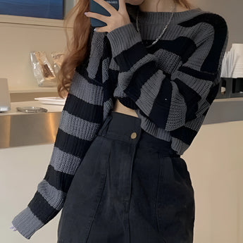 Striped oversized black and white knit sweater featuring a trendy autumn fashion design with long sleeves and a round neckline.