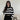 
A stylish oversized knit sweater with black and white stripes, modeled by a person wearing sunglasses. The focus is on the sweater's loose fit and trendy design, perfect for autumn fashion. The sweater features long sleeves and a comfortable neckline.