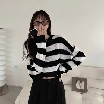 Oversized black and white striped knit sweater with a high collar and long sleeves, ideal for trendy autumn fashion.