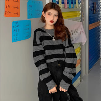 Black and white striped oversized knit sweater with long sleeves and a round collar, styled for trendy autumn fashion.