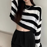 
A stylish black and white striped oversized knit sweater, perfect for autumn fashion, shown on a model wearing an XL size. The sweater features long sleeves and a loose fit, highlighting the shoulders and neck.