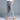 A woman wearing blue striped slim fit ankle-length trousers in a stylish monochrome fashion, showcasing the XXL size.