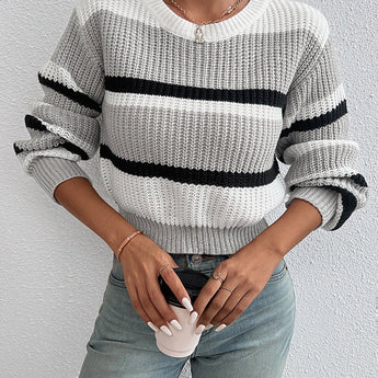 Striped women's black and white crew neck sweater displayed on a mannequin, showcasing its chic winter knitwear design with emphasis on the neckline and shoulder area.