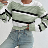 Striped women's black and white crew neck sweater, featuring a chic winter knitwear design, worn by a person demonstrating the fit and style of the sweater.