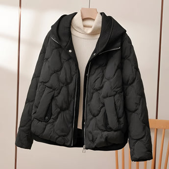 
A stylish black quilted insulated puffer jacket featuring a high collar and long sleeves, designed for fashion-forward individuals. The material appears natural, providing warmth and comfort, suitable for winter wear.