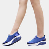 Blue slip-on mesh sneakers with air-cushion sole, designed for comfort and style, featuring electric blue accents; displayed on a human leg.