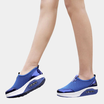 Blue slip-on mesh sneakers with air-cushion sole, designed for comfort and style, featuring electric blue accents; displayed on a human leg.