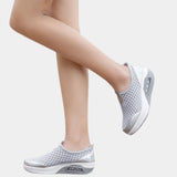 Slip-on mesh sneakers in stylish black with an air-cushion sole; shown in gray color variant, size 42, worn on a human leg.