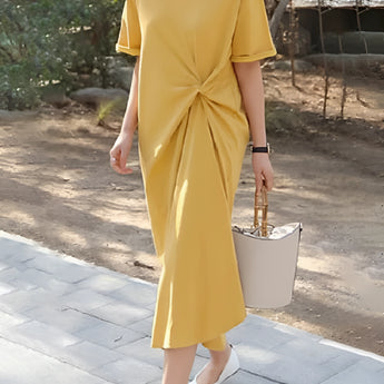 Stylish green twisted tee featuring a knot detail at the front, short sleeves, and a round neckline. The tee is designed for a fashionable look, highlighting the shoulder and waist areas.