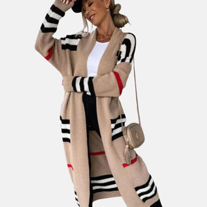 
A woman wearing a stylish oversized knit cardigan in beige and black stripes, featuring long sleeves and an open front design; the cardigan is in a Brown XXL size, showcasing a relaxed fit.
