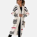Stylish oversized women's striped knit cardigan in beige and black, featuring long sleeves, a relaxed fit, and a classic striped pattern, worn by a model.