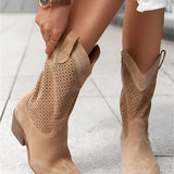 A pair of stylish brown women's perforated Western ankle cowboy boots, shown from the side, highlighting their intricate design and fashionable appeal.