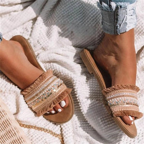 Stylish women's beaded fringe sandals featuring a bohemian chic design, showcasing intricate beadwork and decorative fringes on the straps, perfect for a summer look.