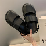 Stylish women's black platform orthopedic sandals with ankle strap, shown worn on a model's feet, highlighting comfort and fashion-forward design.