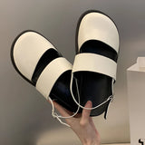 Stylish women's black platform orthopedic sandals with ankle strap, shown on a model's foot, highlighting the comfort and design of the sandal.