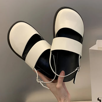 Stylish women's black platform orthopedic sandals with ankle strap, shown on a model's foot, highlighting the comfort and design of the sandal.