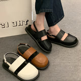 Stylish women's black platform orthopedic sandals with an ankle strap, featuring a modern design and comfortable fit, shown on a model wearing a dress.